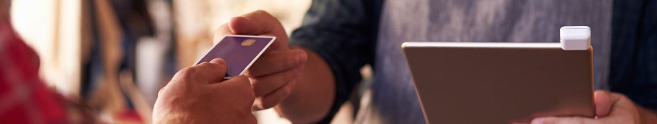 Man handing card to employee to swipe for payment