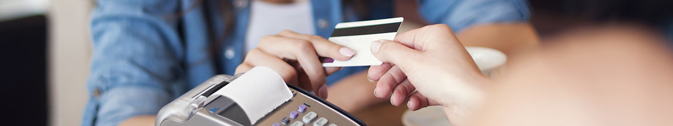 Woman handing card to be swipe with credit card machine.