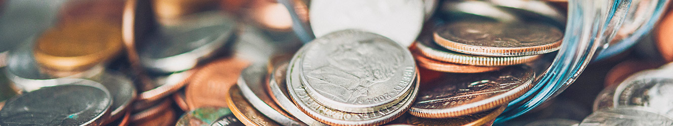 Jar of coins spilling out onto pile.